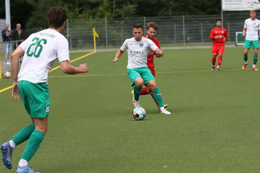 Lennart Bossen (TSV Klausdorf) schirmt nach einem Zuspiel von Maik Gorn (26) den Ball vor Marvin Lorentzen (Inter Türkspor Kiel) ab.
