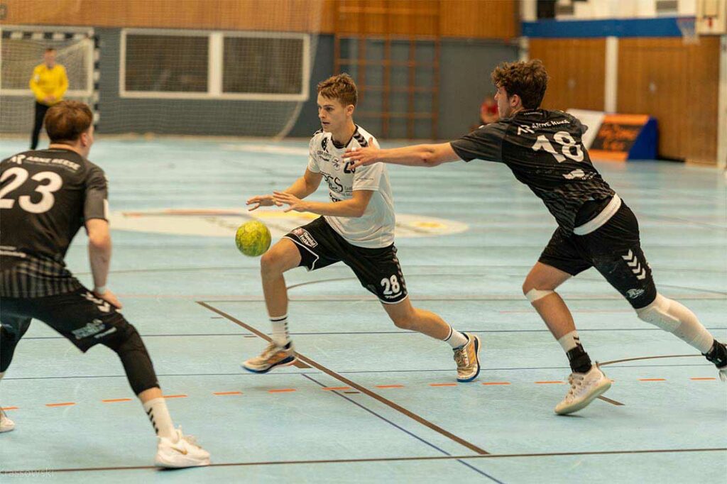 Oke Petersen (mitte, SG Eider-Harde) hat Ball und Anspielstation gleichzeitig im Blick. © 2022 Daniel Krassowski