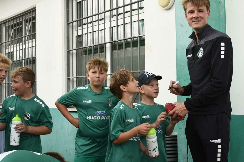 Cheftrainer Lukas Pfeiffer (VfB Lübeck) nimmt sich die Zeit für die Autogrammwünsche der jungen Fans. © 2023 Olaf Wegerich