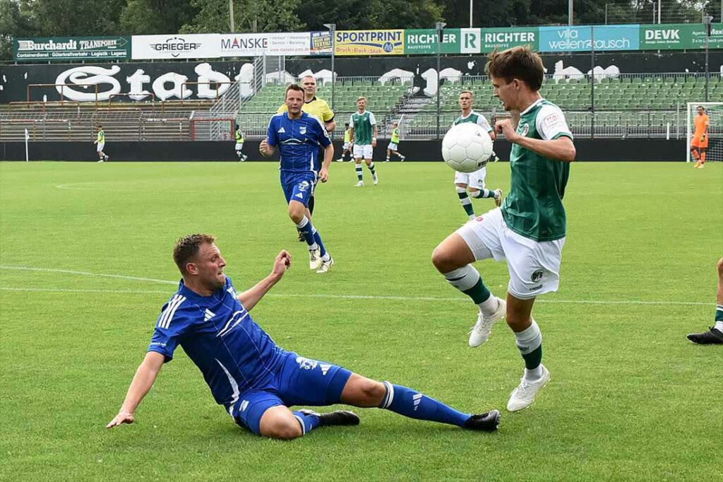 Dennis Bienwald (li., TuS Rotenhof) versucht mit einer Grätsche, Jorik Wulff (VfB Lübeck) vom Ball zu trennen. © 2024 Olaf Wegerich