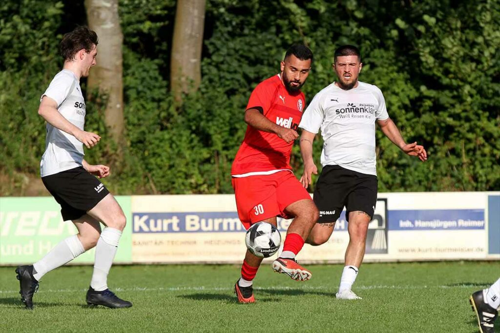 Serhat Yazgan (am Ball, Kilia Kiel) war im Pokalspiel in Kronshagen dabei. Rechts Prempton Jasari (TSV Kronshagen), links Julian Huchzermeier. © 2024 Ismail Yesilyurt