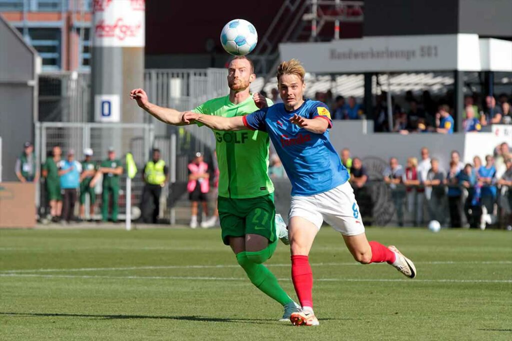 Finn Porath (re., Holstein Kiel) holt sich diesen Ball gegen Maximilian Arnold (VfL Wolfsburg). © 2024 Ismail Yesilyurt