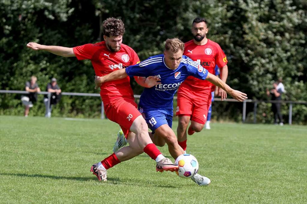 Zwei Freunde, die sich auf dem grünen Rasen sportlich messen. Sercan Yildirimer (li.) spitzelt Luca Aouci (Kilia Kiel) den Ball weg. © 2024 Ismail Yesilyurt