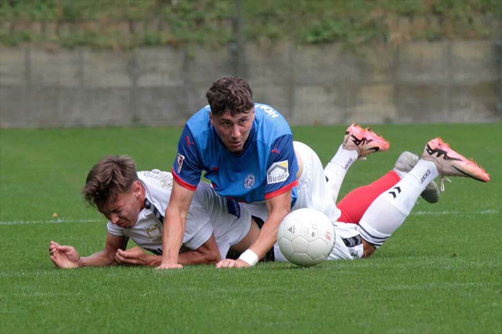 Quentin Seidel (Holstein Kiel II) obenauf und Jonathan Stöver (1. FC Phönix Lübeck) unten nach dem Zweikampf. © 2024 Ismail Yesilyurt