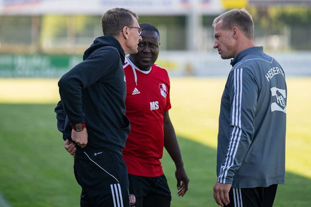 Das Heider Trainer-Trio bespricht die Anweisungen an ihr Team. © 2024 Volker Schlichting