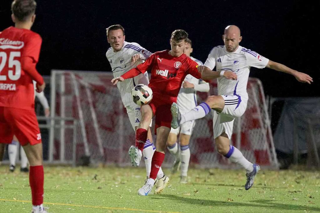 Marvin Müller (mitte, Kilia Kiel) erzielt wie zuletzt gegen Rotenhof das 1-0.  Rechts Christian Schrum (Rotenhof) sowie Kenneth Traulsen. © 2024 Ismail Yesilyurt