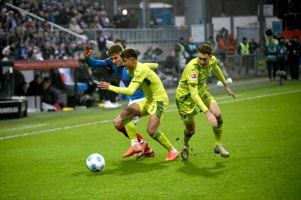 Phil Harres (Holstein Kiel) gegen Tom Bischof und Arthur Chaves (TSG Hoffenheim). © 2025 Olaf Wegerich