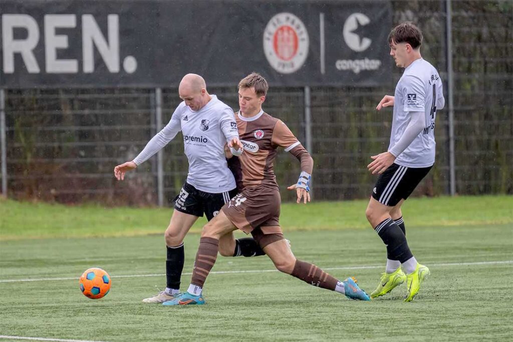 Steffen Neelsen (Heider SV) ist schneller am Ball als Toralf Hense (FC St. Pauli II). © 2025 Volker Schlichting