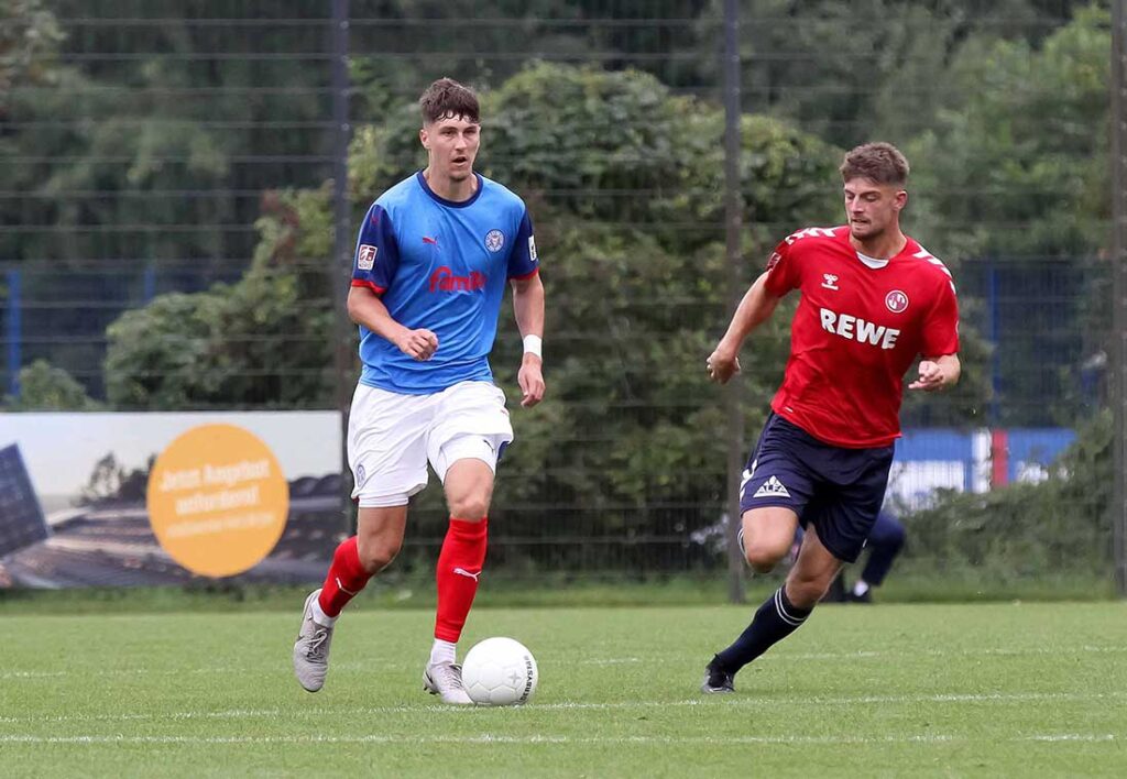 Verteidiger Quentin Seidel (li., Holstein Kiel II) rückt bei Standards mit auf und hatte eine Möglichkeit gegen den VfB Lübeck. © 2024 Ismail Yesilyurt