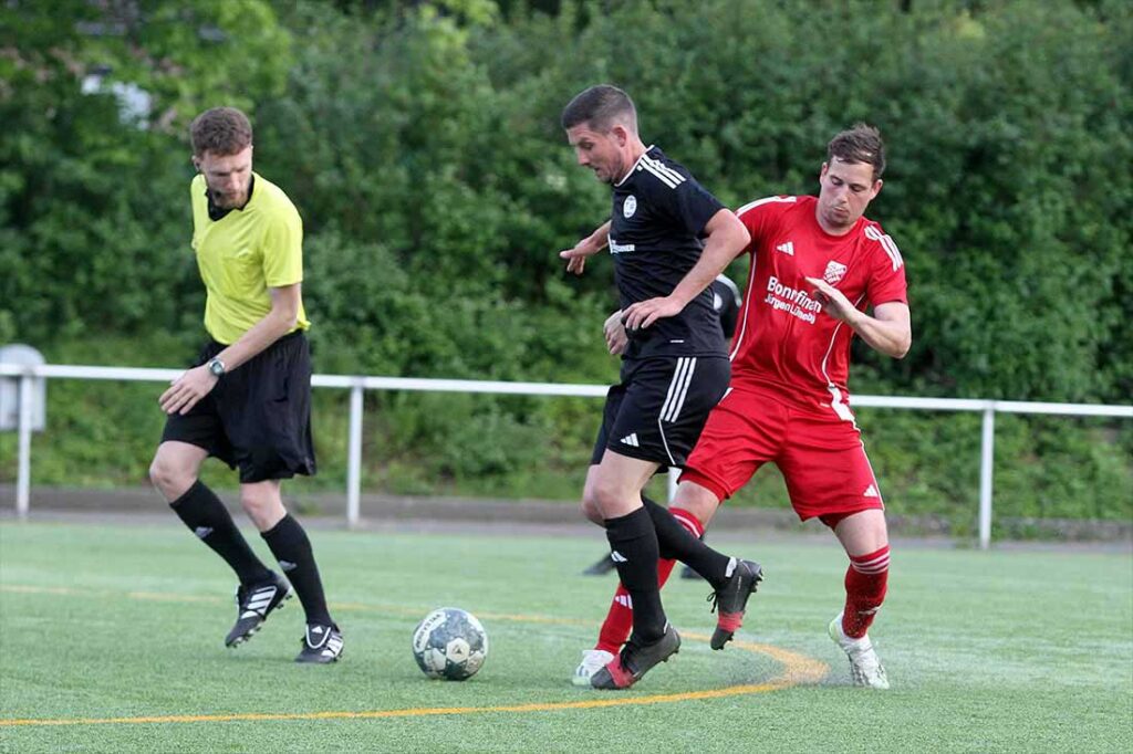 Torben Frahm (TSV Flintbek) bringt gleich vor den Augen des Referee Marcel Maasch (SG Sarau-Bosau) zu Fall. © 2025 Ismail Yesilyurt