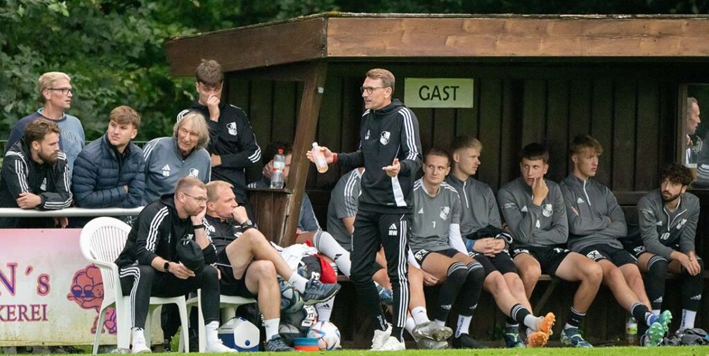 Chefcoach Markus Wichmann (Heider SV) diskutiert ein Spielszene mit SR-Assistent Lukas Klingelhöfer. © 2025 Volker Schlichting
