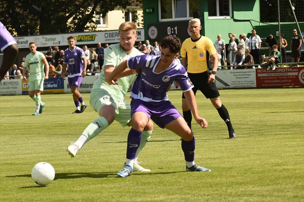 Duell der Mittelfeldzentralen - Calvin Ehlert (PSV neumünster) bedrängt Visar Mehmeti (VfR Neumünster). © 2025 Olaf Wegerich