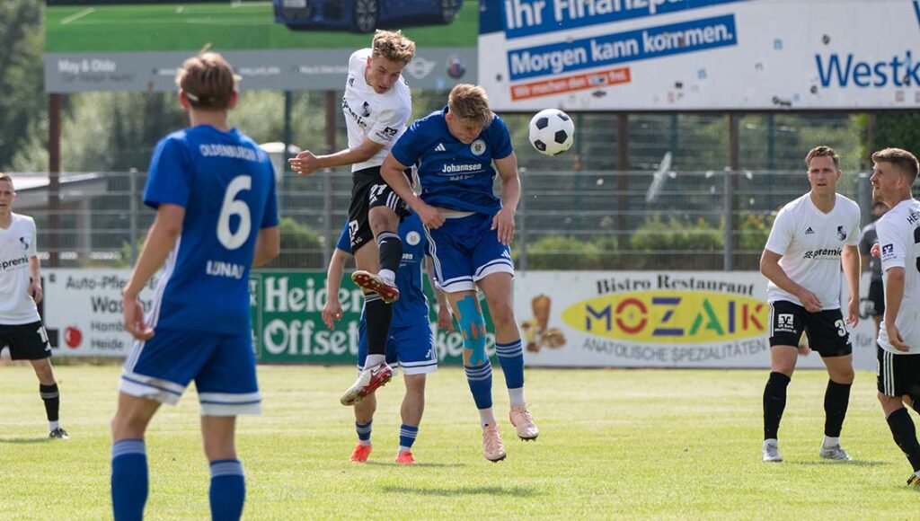 Thede Reimers (in weiss, Heider SV), der später trifft, beim Kopfball mit Thorge Salke (Oldenburger SV). © 2025 Volker Schlichting