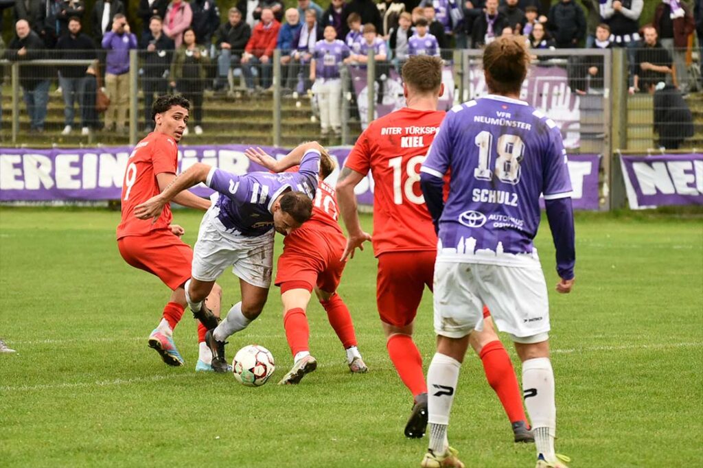 Die Szene, die zur Entscheidung führt - Kastriot Alija (VfR Neumünster) zwischen Santino Laubinger (li.) und Justin Petersen (Inter Türkspor Kiel. © 2025 Olaf Wegerich
