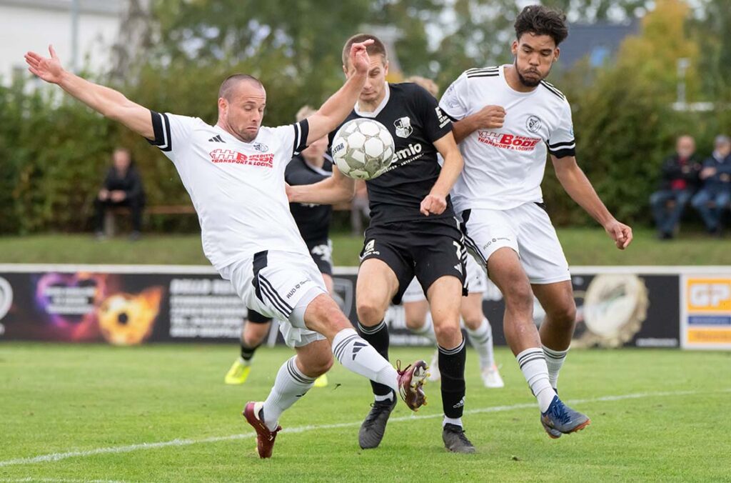 Marvin Wolf (Heider SV) zwischen Tim Vogel (li.) und Emilio Krück (Preußen Reinfeld). © 2025 Volker Schlichting
