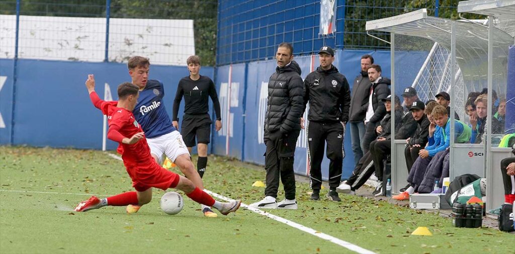 Neutrainer Karim Youssef beobachtet wie sein Spieler Pascal Polonski versucht, Leon Parduzi (Holstein Kiel II) den Ball abzugrätschen. © 2025 Ismail Yesilyurt