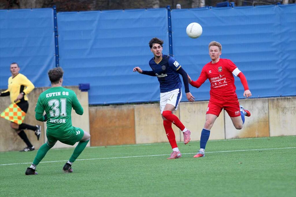 Jorden Winter (Holstein Kiel II) bringt einen Ball rein, findt aber nicht den richtigen Abnehmer. Links Keeper Luca Kiecok und Kapitän Philip Kunert (Eutin 08). © 2025 Ismail Yesilyurt 