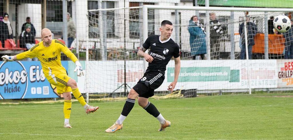 Der schmerzlichst vermisste Torjäger Mika Kieselbach (Heider SV) ist wieder back auf dem Platz. Hier klärt Reinfelds Keeper Daniel Marco vor dem Torjäger. © 2026 Volker Schlichting