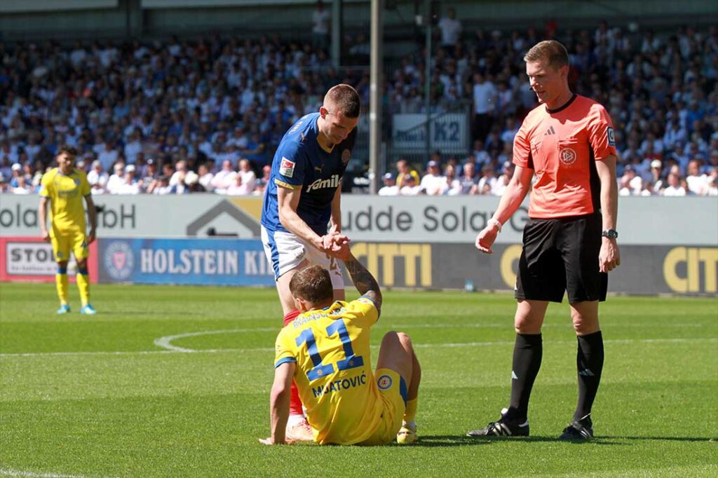 Punktemäßig gab es von Holstein Kiel keine Unterstützung für die Braunschweiger. Hier hilft David Zec Braunschweigs Jovan Mijatovic auf die Beine. © 2026 Ismail Yesilyurt