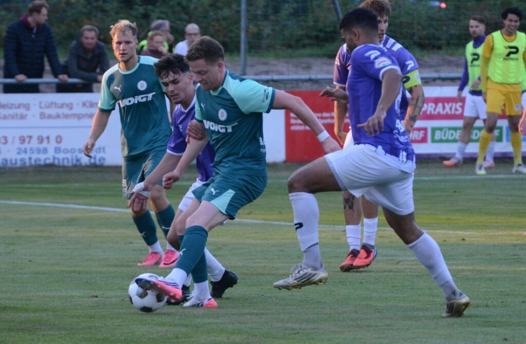 Marvin Ehlert (PSV Neumünster) wird von Visar Mehmeti (li) und Noah Awuku (VfR Neumünster) bedrängt. © 2026 Olaf Wegerich