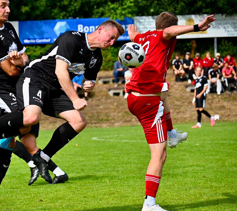 Fabian Weichbrodt (TS Einfeld) köpft den Ball hinter Niklas Kock (TSV Flintbek) weg. Links Mitspieler Brian Casper. © 2026 Meryem Manke