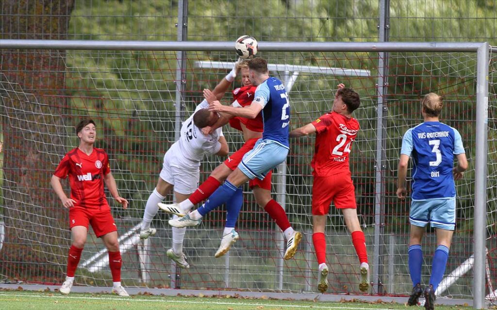 Keeper Nikolas Wulf und Lucas Groß (Kilia Kiel) gemeinsam gegen Felix Knuth (TuS Rotenhof) nach einem Eckball.© 2026 Ismail Yesilyurt