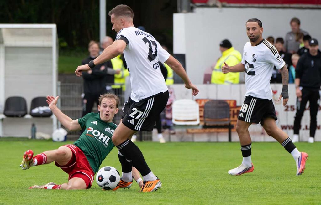 Tim Sienknecht (MTSV Hohenwestedt versucht, mit einer Grätsche Jonah Gieseler (Heider SV) aufzuhalten. © 2026 Volker Schlichting