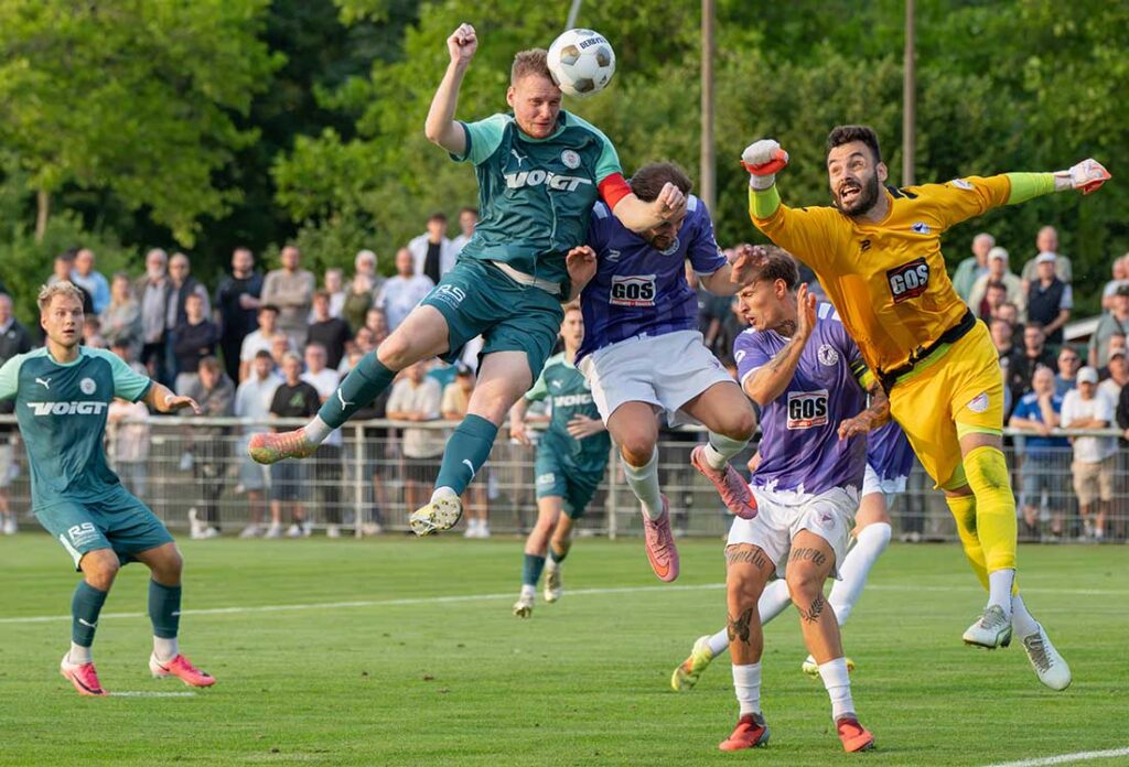 Timo Barendt (PSV Neumünster) ist mit dem Kopf eher am Ball als Keeper Christopher Newe mit der Faust - ein Tor wird es dennoch nicht. © 2026 Volker Schlichting
