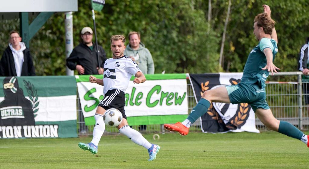 Lennart Busch (Heider SV) kommt vor Meiko Werner (PSV Neumünster) zum Flanken. © 2026 Volker Schlichting